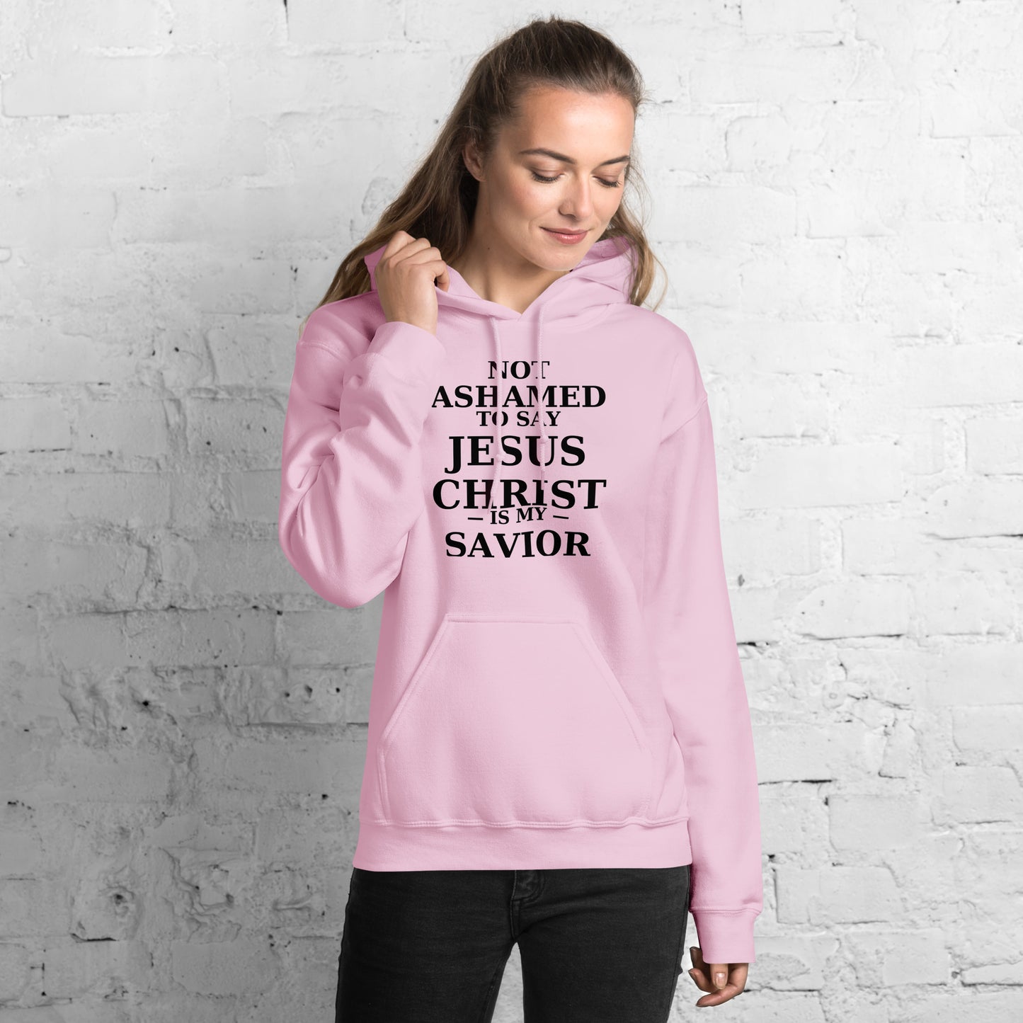 “Pink Christian hoodie with the bold faith message ‘Not Ashamed to Say Jesus Is My Savior’ in modern typography. Inspirational Scripture-based apparel for evangelism and everyday Christian streetwear.”