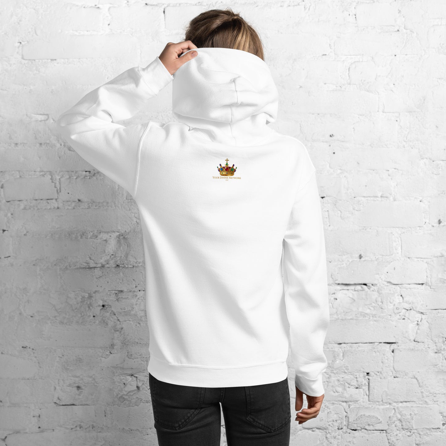 Person wearing a white hoodie with 'inner' text on the back against a white brick wall.