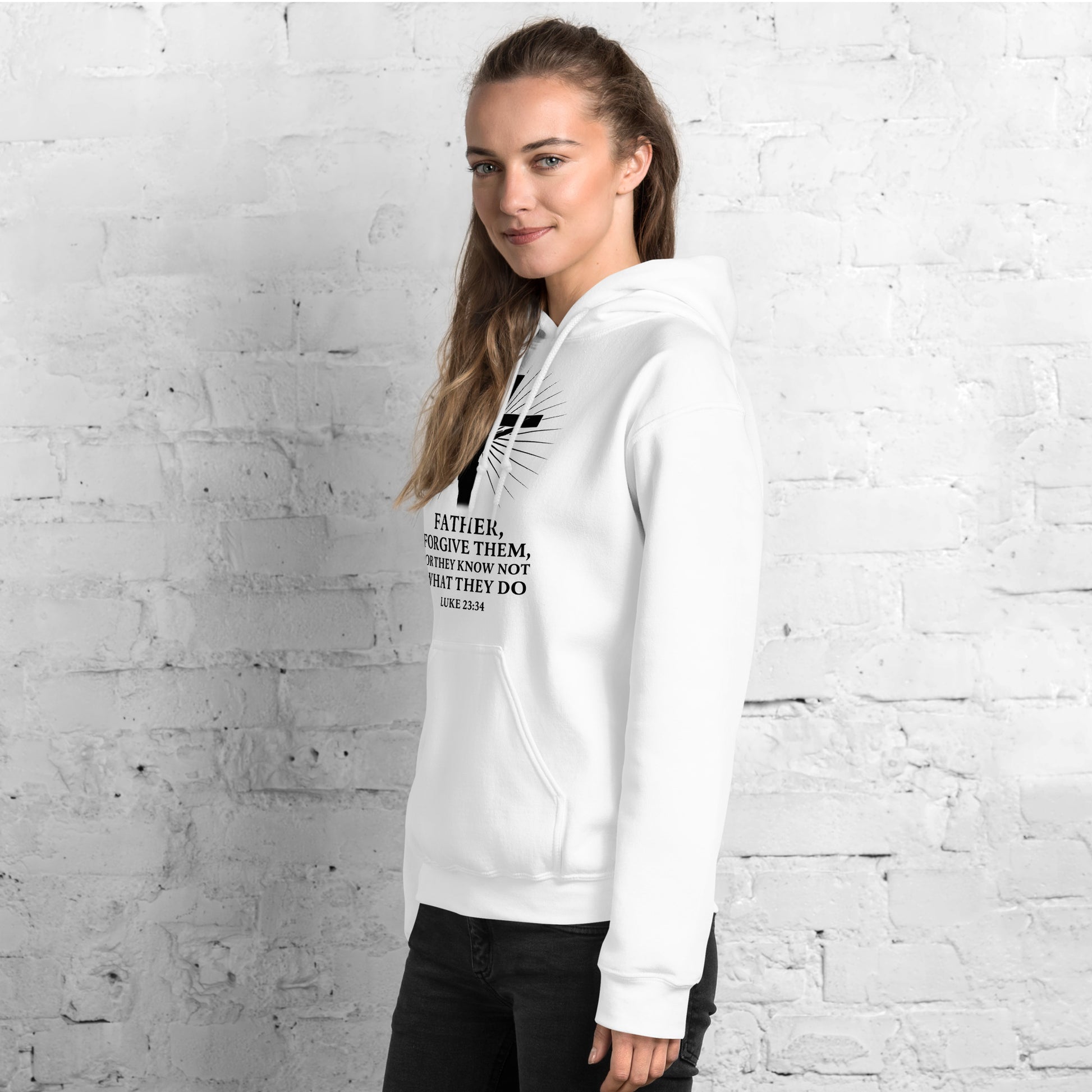 Person wearing a white hoodie against a light gray brick wall