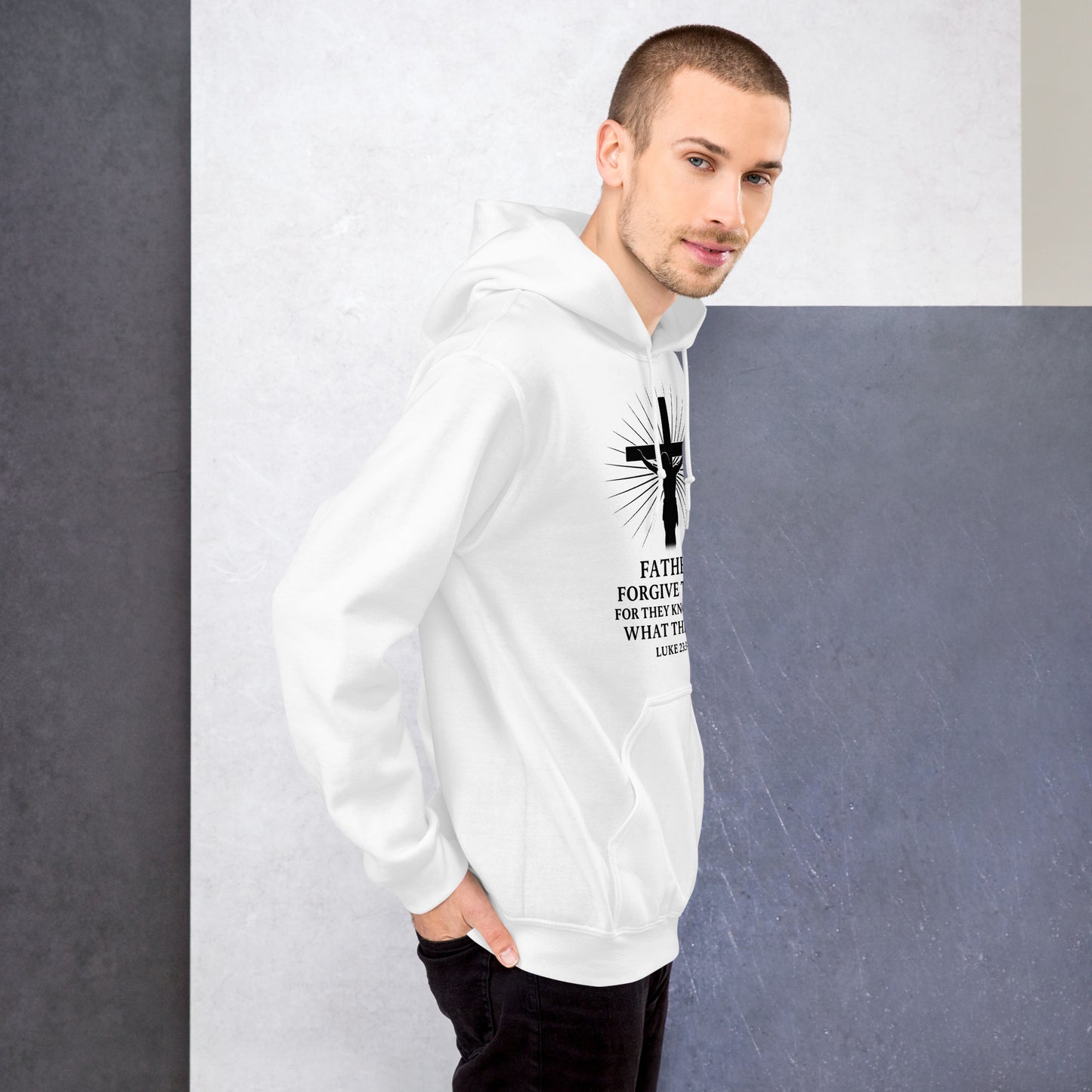 Man wearing a white hoodie with a black cross design and text against a gray background
