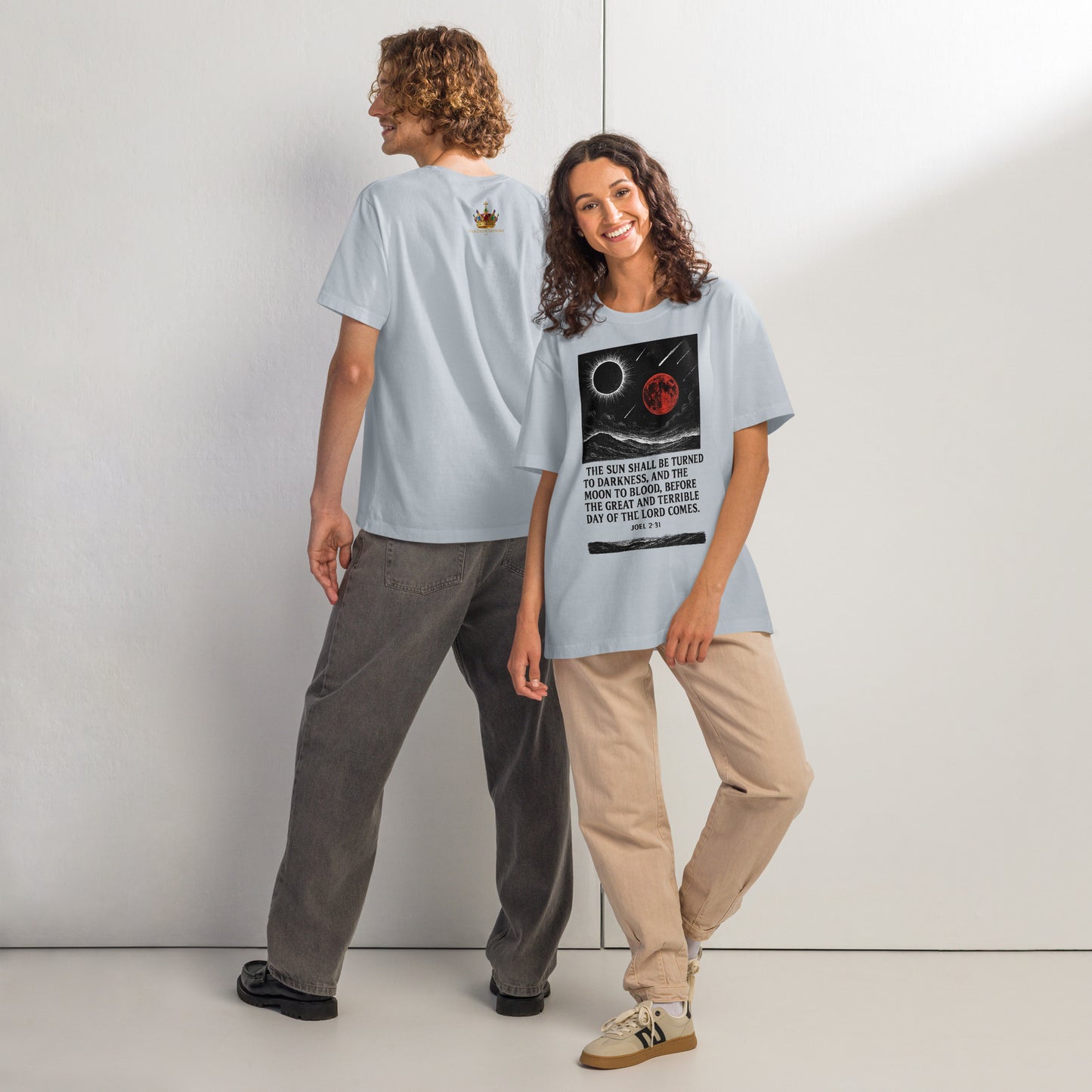 Two people wearing light blue t-shirts with graphic designs, standing side by side against a plain background.